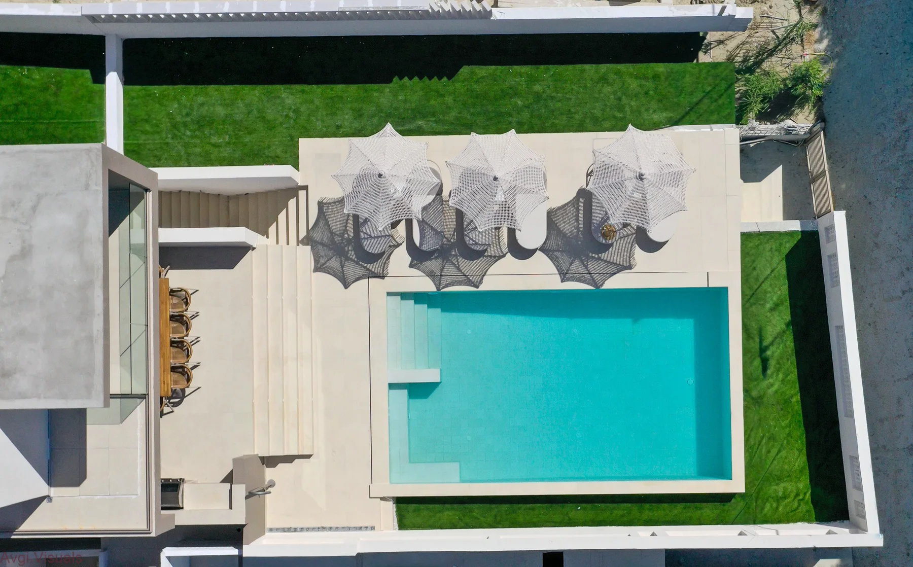 Top-down aerial photograph of a luxury villa with pool and outdoor lounge by Avgi Chourlia