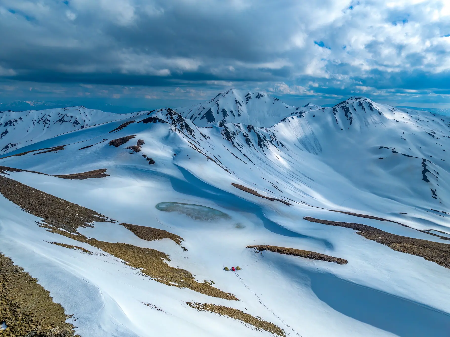 Aerial documentary photograph of a snow-covered mountain landscape and expedition camp by Kafetsis A. Fotis