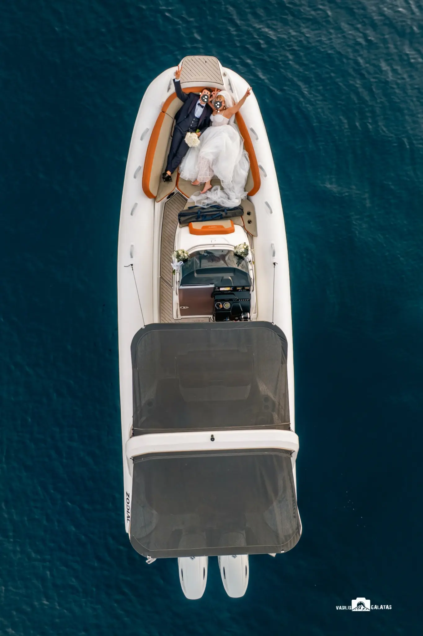 Aerial wedding photograph of a couple on a boat by Basilis Galatas