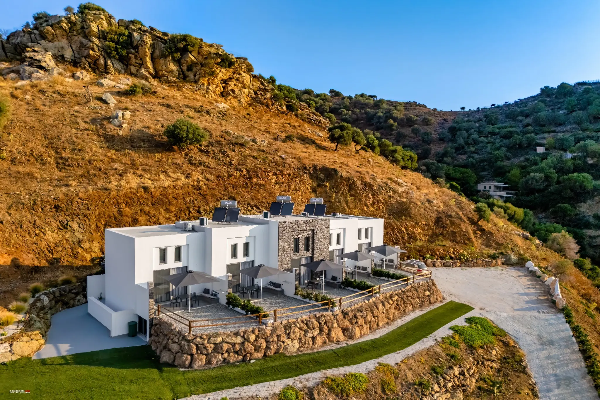 Aerial photograph of hillside holiday accommodation by Zisimos Zizos